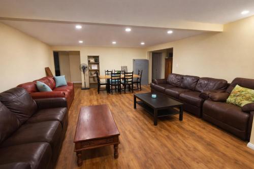 a living room with leather couches and a table at Santa Ana Love Home in Santa Ana