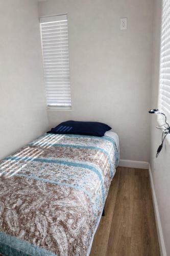 a bedroom with a bed with a blue pillow on it at Santa Ana Love Home in Santa Ana