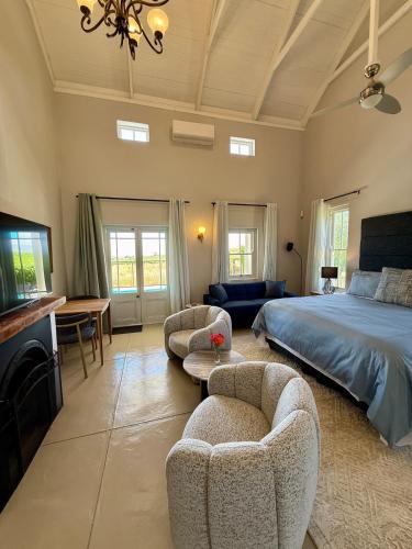 a bedroom with a bed and two chairs and a couch at Grand View Cottages - 2 King Suites - Entire Cottage in Riebeek-Kasteel