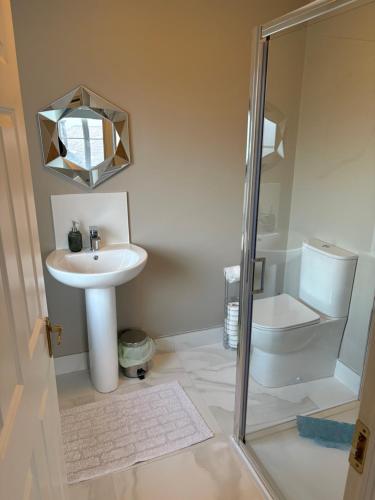 a bathroom with a sink and a toilet and a shower at Seaview in Enniscrone