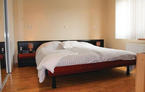 a bedroom with a bed with white sheets and pillows at Seehund 102 in Sint Annaland