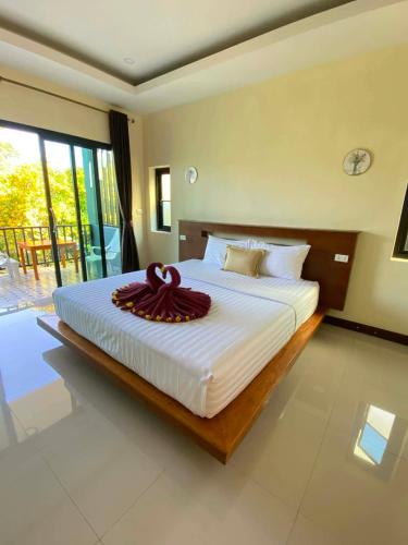 a bedroom with a large white bed with a large window at Dusit Long Beach in Ko Lanta
