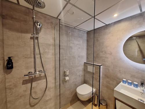 a bathroom with a shower and a toilet and a sink at Fletcher Hotel-Restaurant ‘s-Hertogenbosch in Den Bosch