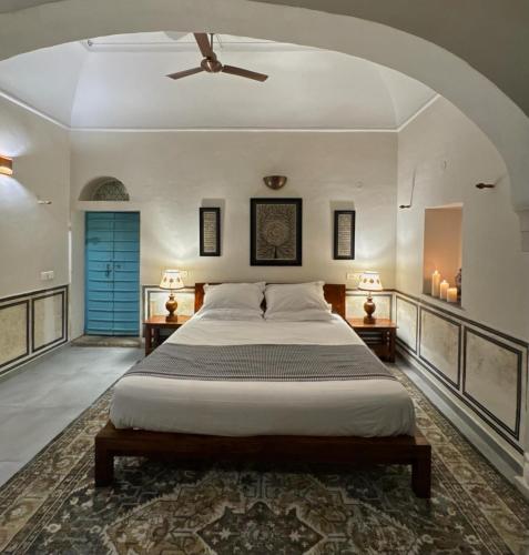 a bedroom with a bed and a ceiling fan at Mandawa Kothi in Mandāwa
