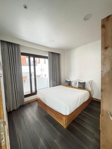 a bedroom with a bed and a large window at HB Apartment in Thimphu in Thimphu