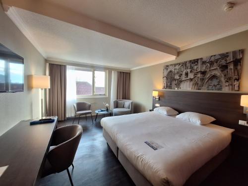 a hotel room with a large bed and a desk at Fletcher Hotel-Restaurant ‘s-Hertogenbosch in Den Bosch