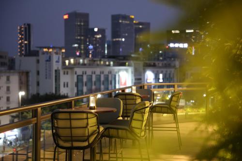 a group of chairs and tables on a balcony with a city skyline at EVEN Hotel Shenzhen Nanshan by IHG in Shenzhen