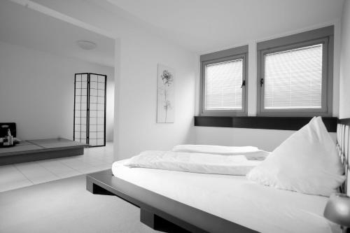 a white room with a bed and two windows at Laerholz 84 in Bochum