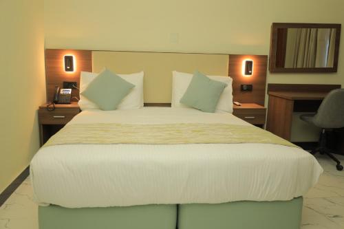 a bedroom with a large white bed with a desk at History Hotel in Dirē Dawa