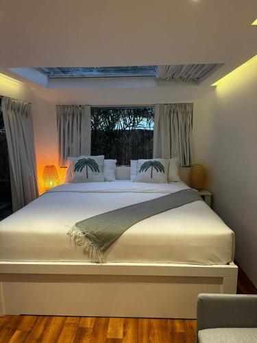 a bedroom with a large white bed with a window at Hidden Valley GLAMPING in Fujairah