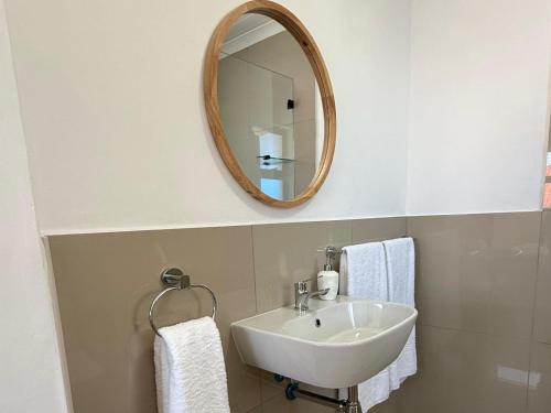 a bathroom with a sink and a mirror at Old Harbour Place in Gansbaai