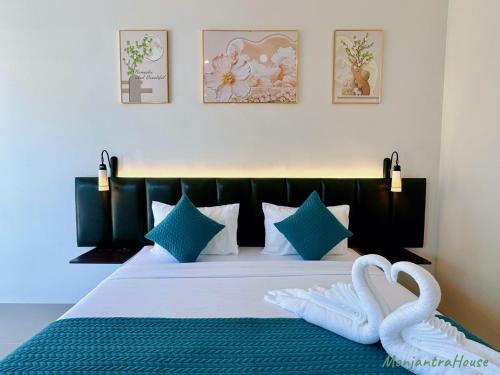 a bedroom with a bed with two swans on it at มนต์จันทรา เฮ้าส์ in Khlong Lan