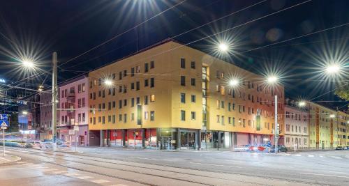a building on a street at night with street lights at PLAZA INN Graz City in Graz