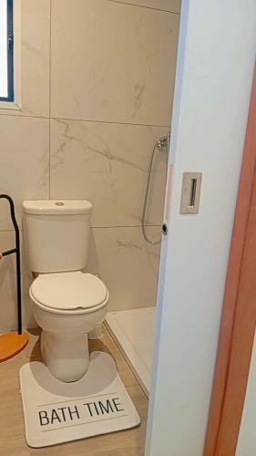 a bathroom with a toilet with a bath time sign on the floor at Farol views in Fajã da Ovelha