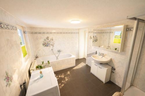 a bathroom with a tub and a sink and a toilet and a bath tub at Apartment-schiefe- Marie in Oberlungwitz