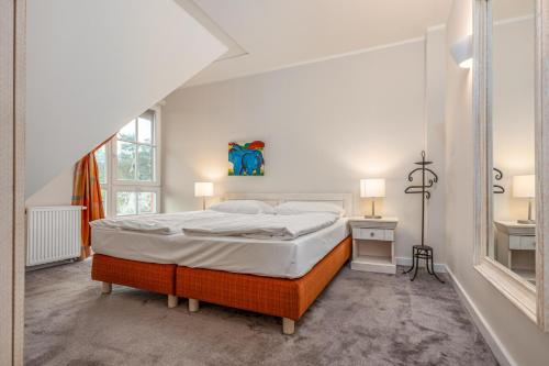 a white bedroom with a bed and a sink at Strandnest in Dierhagen