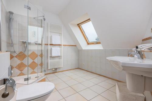 a bathroom with a shower and a toilet and a sink at Strandnest in Dierhagen