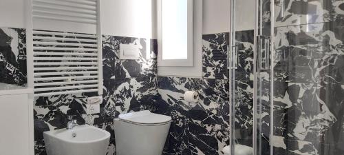 a black and white bathroom with a toilet and a sink at Apartments Marini in Pordenone
