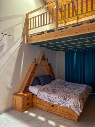 a bed in a room with a wooden bed frame and stairs at Saffron 2 Bedroom Duplex Villa in Mukteshwar