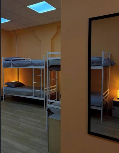 a room with three bunk beds and a mirror at Трініті Хаус in Kyiv