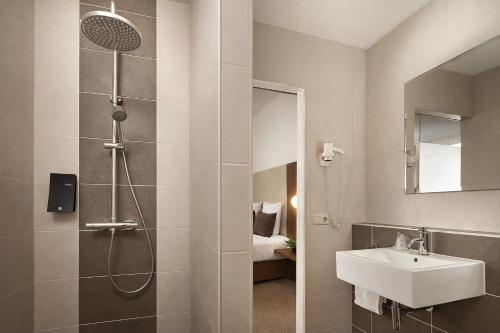 a bathroom with a shower and a sink at Hotel La Reine in Eindhoven