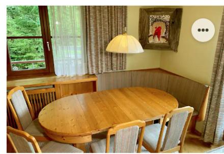 a wooden dining room table with chairs and aendant light at The Mountain Home in Hermagor