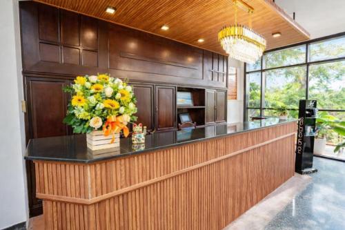a kitchen with a counter with a vase of flowers at Sea and Sand Hotel in Hoi An