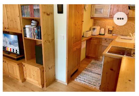 a kitchen with wooden cabinets and a sink and a tv at The Mountain Home in Hermagor