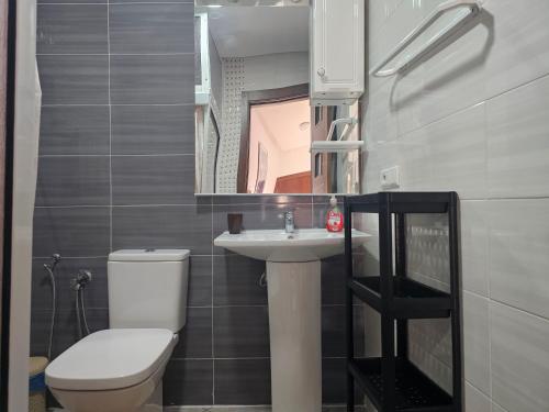 a bathroom with a toilet and a sink and a mirror at Corazón Urbano in Martil