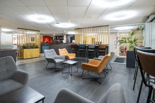 a waiting room with chairs and a bar at Ramada London Stansted Airport in Stansted Mountfitchet