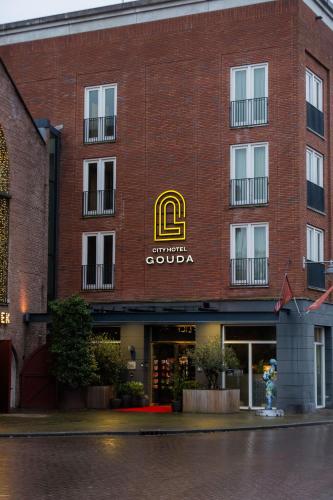 a red brick building with a gold sign on it at City Hotel Gouda, WorldHotels Crafted Collection in Gouda