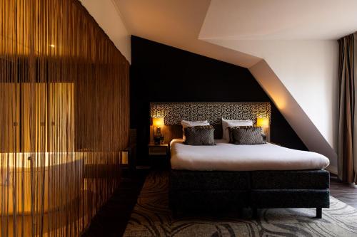 a bedroom with a large bed with two pillows at City Hotel Gouda, WorldHotels Crafted in Gouda
