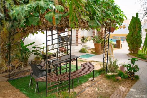 pergola z krzesłami i stołem w ogrodzie w obiekcie Le Patio w mieście Nawakszut