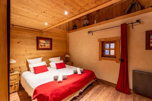 a bedroom with a large bed in a wooden room at Chalet les trois coeurs in Méribel