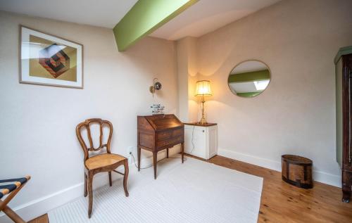 a room with a desk and a chair and a lamp at Le Logis Tournusien in Tournus