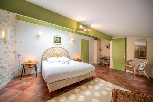 a bedroom with a bed and green walls at Le Logis Tournusien in Tournus