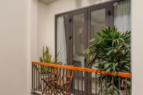 a balcony with two chairs and some plants at NA Hoian Hotel in Hoi An