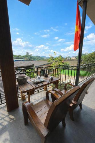 a patio with a table and benches on a balcony at BG Stone Homestay in Mộc Châu