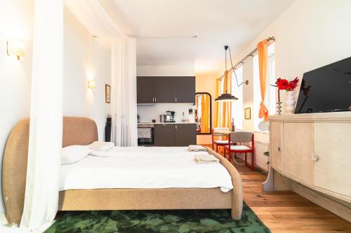 a bedroom with a large bed and a kitchen at Entspanntes Design-Studio an der Karli in Leipzig