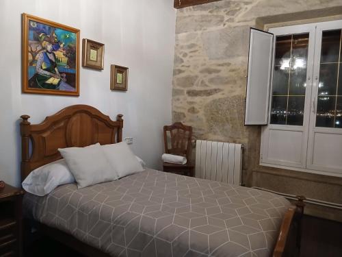 a bedroom with a bed and a window at Casa de Romaxe in Muros