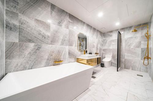 a bathroom with a white tub and a sink at Den Basta hotel in Yangsan