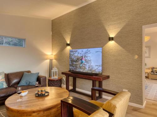 a living room with a couch and a table with a tv at Walker Bay Villa in Gansbaai