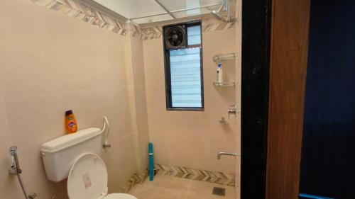 a bathroom with a toilet and a window at Hideout 2bhk Kharadi Near EON in Pune