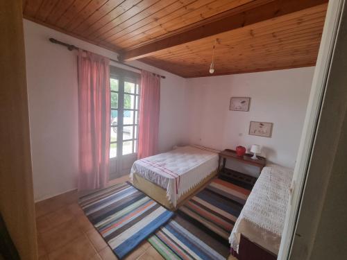 a bedroom with a bed and a window at Ektor Villa in Agios Georgios