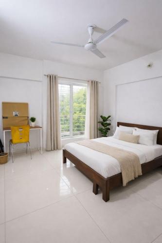 a white bedroom with a large bed and a window at Hideout 2bhk Kharadi Near EON in Pune