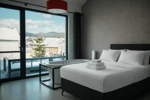 a bedroom with a bed and a view of a balcony at Chalet Rufux in Dolná Lehota
