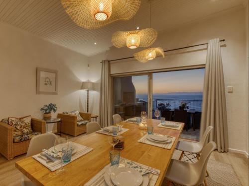 a dining room with a table and a view of the ocean at Walker Bay Villa in Gansbaai