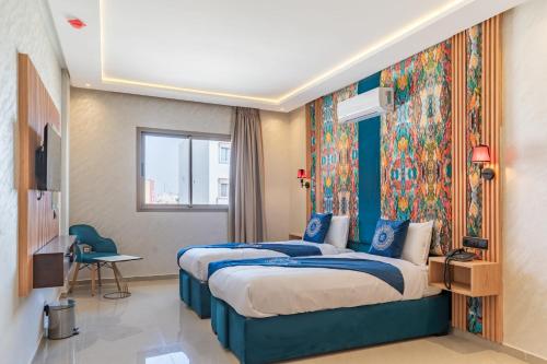 a bedroom with a large bed with a colorful headboard at Hotel Rhali Dakhla in Dakhla