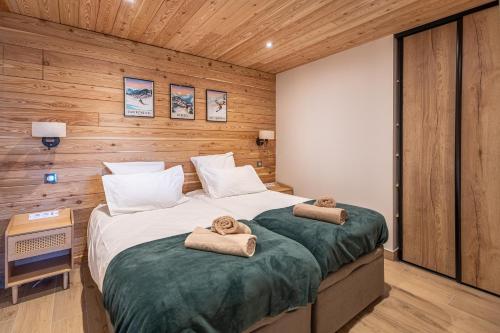 a bedroom with two beds with towels on them at Appartement Marmotte in Méribel