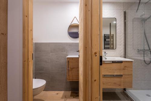 a bathroom with a sink and a toilet and a mirror at Appartement Marmotte in Méribel